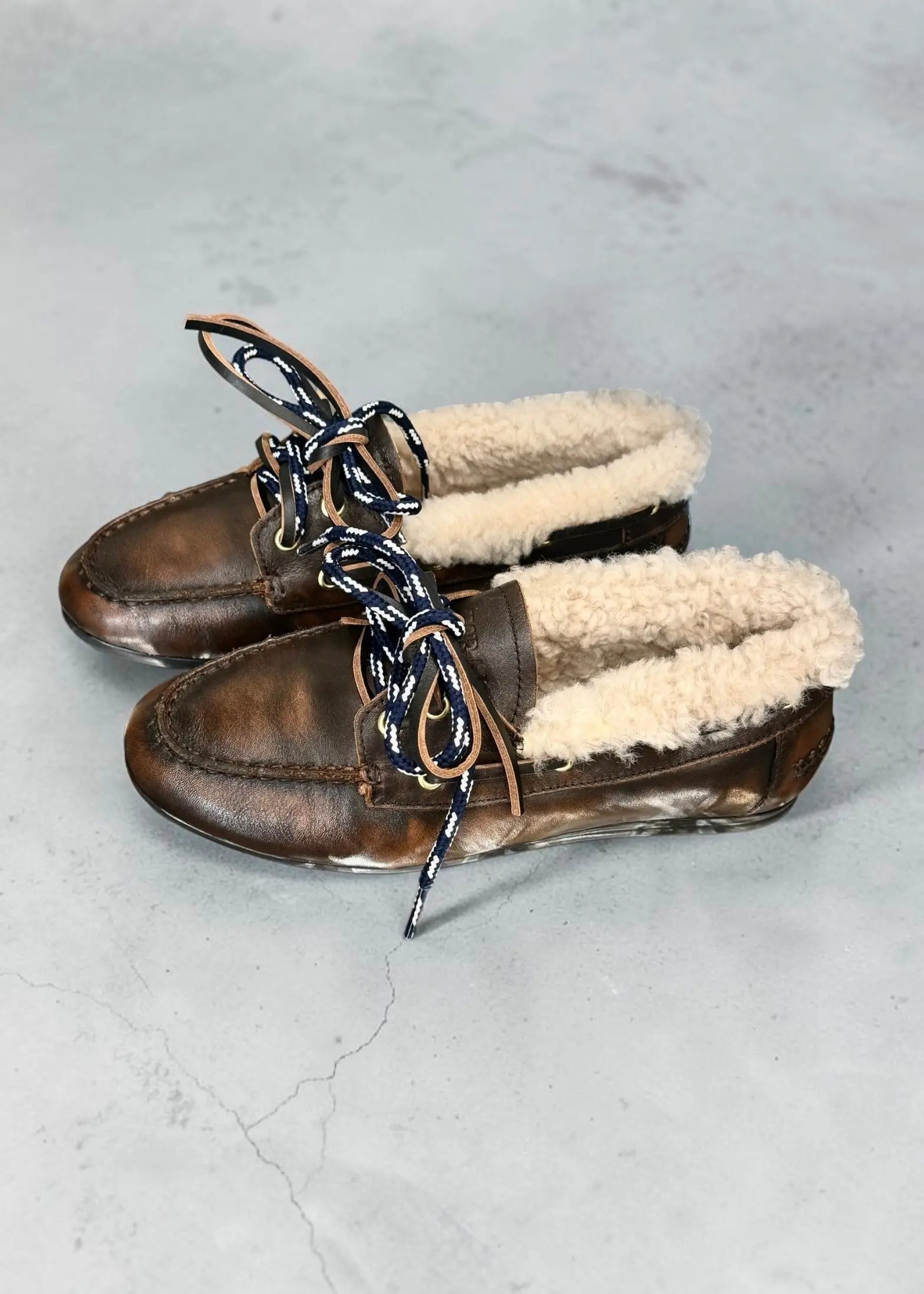 Mocassins Toral Nahua cuir marron fourrés sur fond gris, détail sur la texture et le confort en fourrure.
